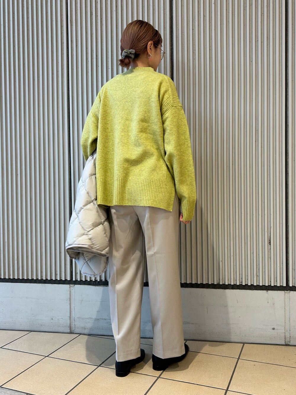 グリーン系のニット/セーター、ベージュ系のその他パンツ、ブラック系のブーツを着用したレディースの冬コーディネートの2枚目の写真