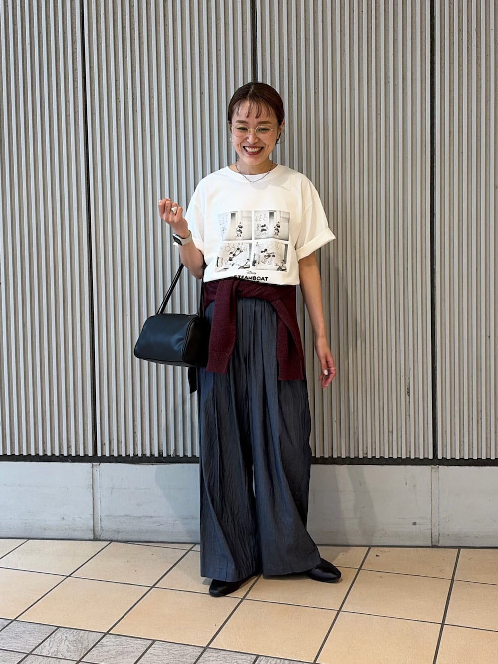 ホワイト系のTシャツ/カットソー、ブルー系のデニムパンツ、ブラック系のハンドバッグを着用したレディースの夏コーディネートの4枚目の写真