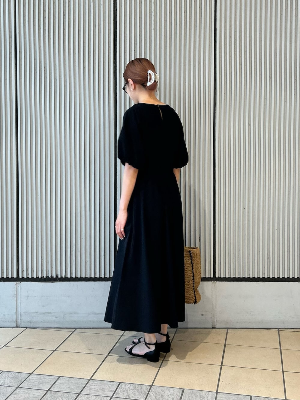 ベージュ系のトートバッグ、ブラック系のサンダル、ブラック系のワンピースを着用したレディースの春コーディネートの2枚目の写真