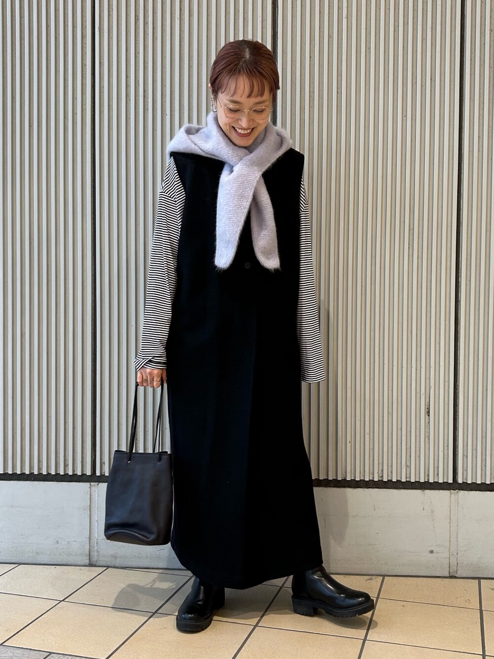 ブラック系のワンピース、ブラック系のTシャツ/カットソー、ブラック系のショルダーバッグを着用したレディースの秋コーディネートの4枚目の写真