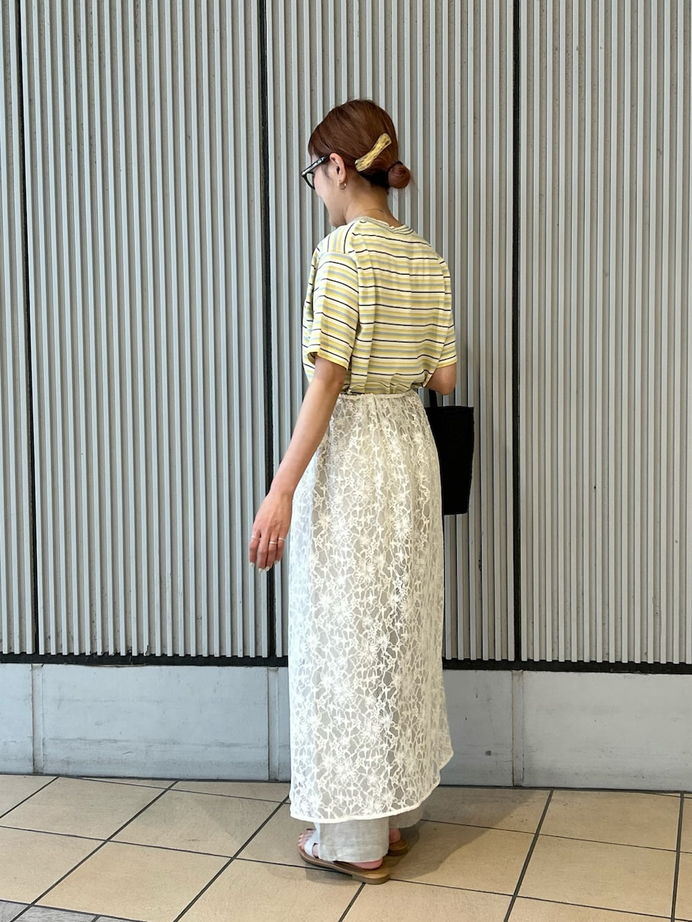 ブラウン系のかごバッグ、ベージュ系のその他パンツ、ホワイト系のサンダルを着用したレディースの夏コーディネートの2枚目の写真