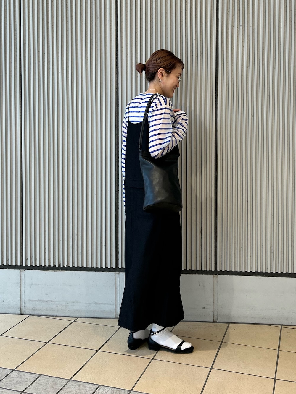 ブラック系のサンダル、ブルー系のTシャツ/カットソー、ブラック系のワンピースを着用したレディースの春コーディネートの2枚目の写真