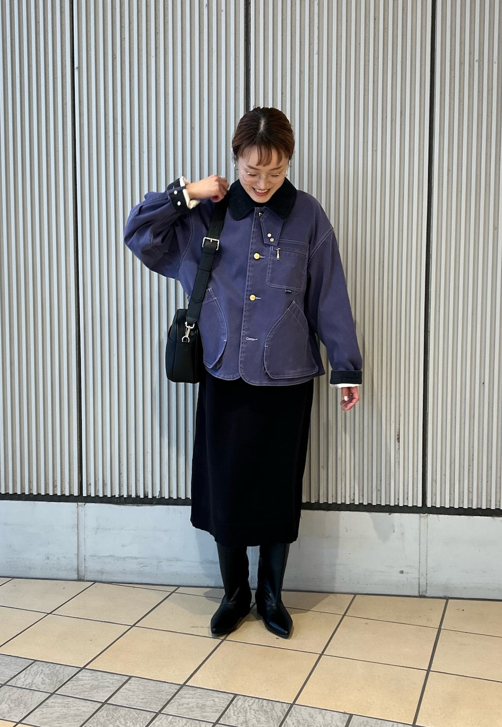 ブルー系のテーラードジャケット、ブラック系のワンピース、ブラック系のブーツを着用したレディースの冬コーディネートの3枚目の写真