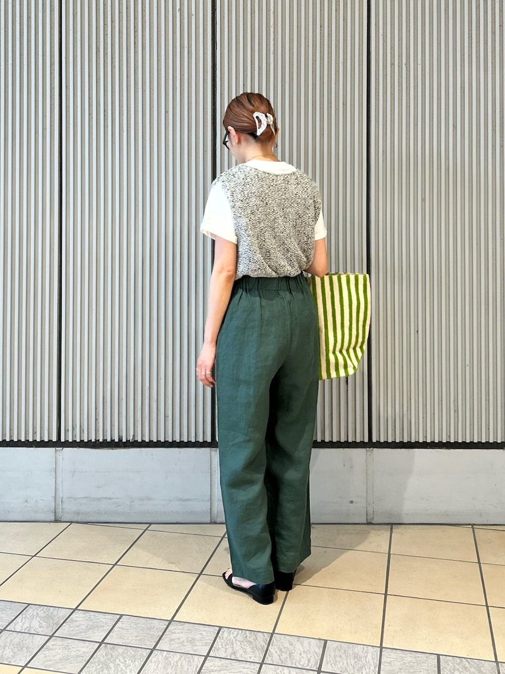 グリーン系のその他パンツ、グレー系のニット/セーター、ホワイト系のTシャツ/カットソーを着用したレディースの春コーディネートの2枚目の写真