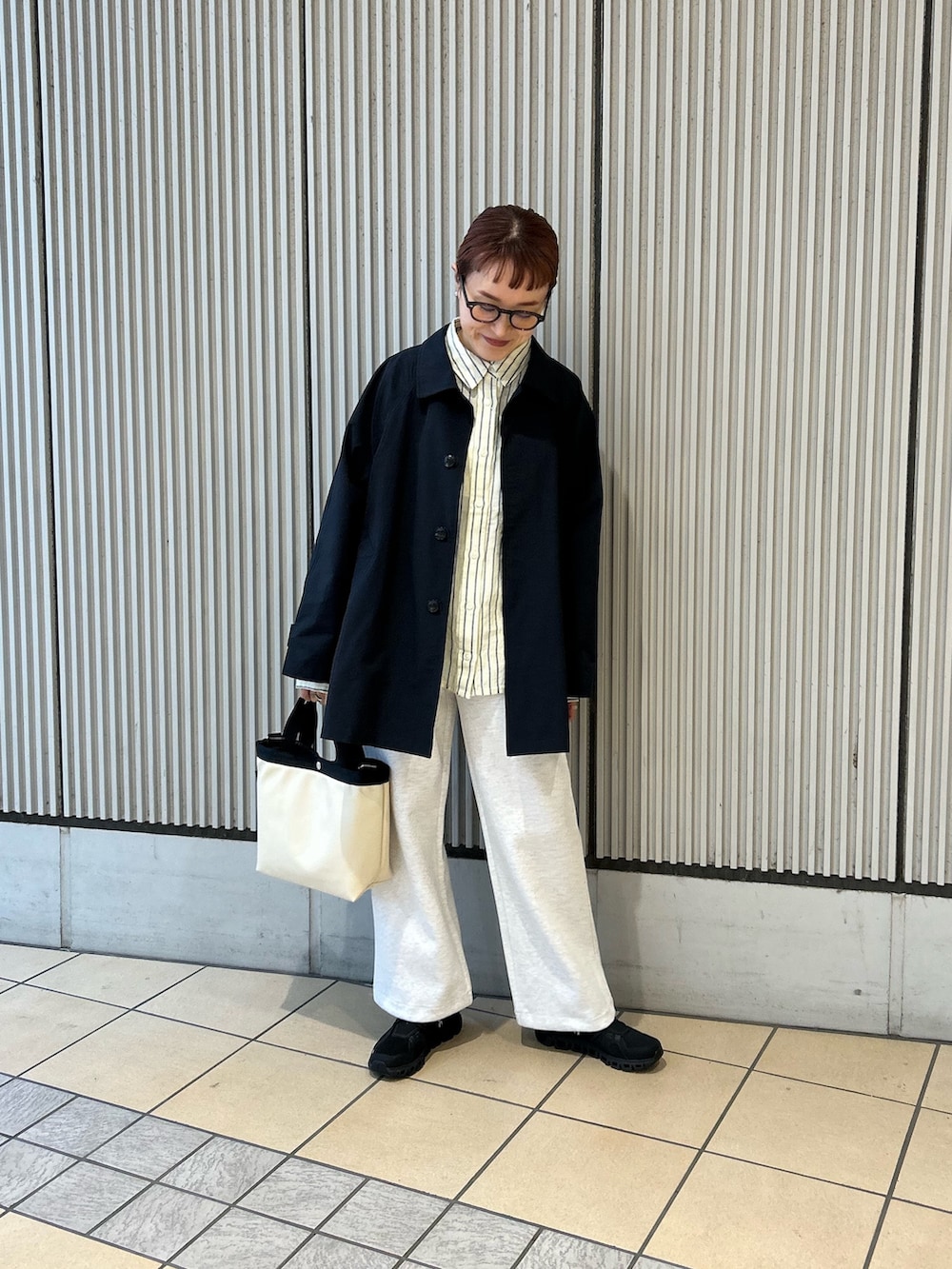 イエロー系のシャツ/ブラウス、ブルー系のステンカラーコート、グレー系のその他パンツを着用したレディースの春コーディネートの4枚目の写真