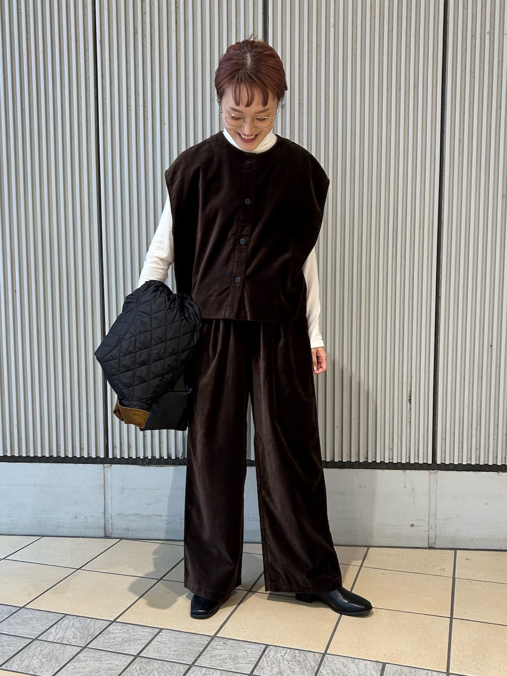 ブラック系のその他アウター、ブラック系のハンドバッグ、ホワイト系のTシャツ/カットソーを着用したレディースの秋コーディネートの4枚目の写真