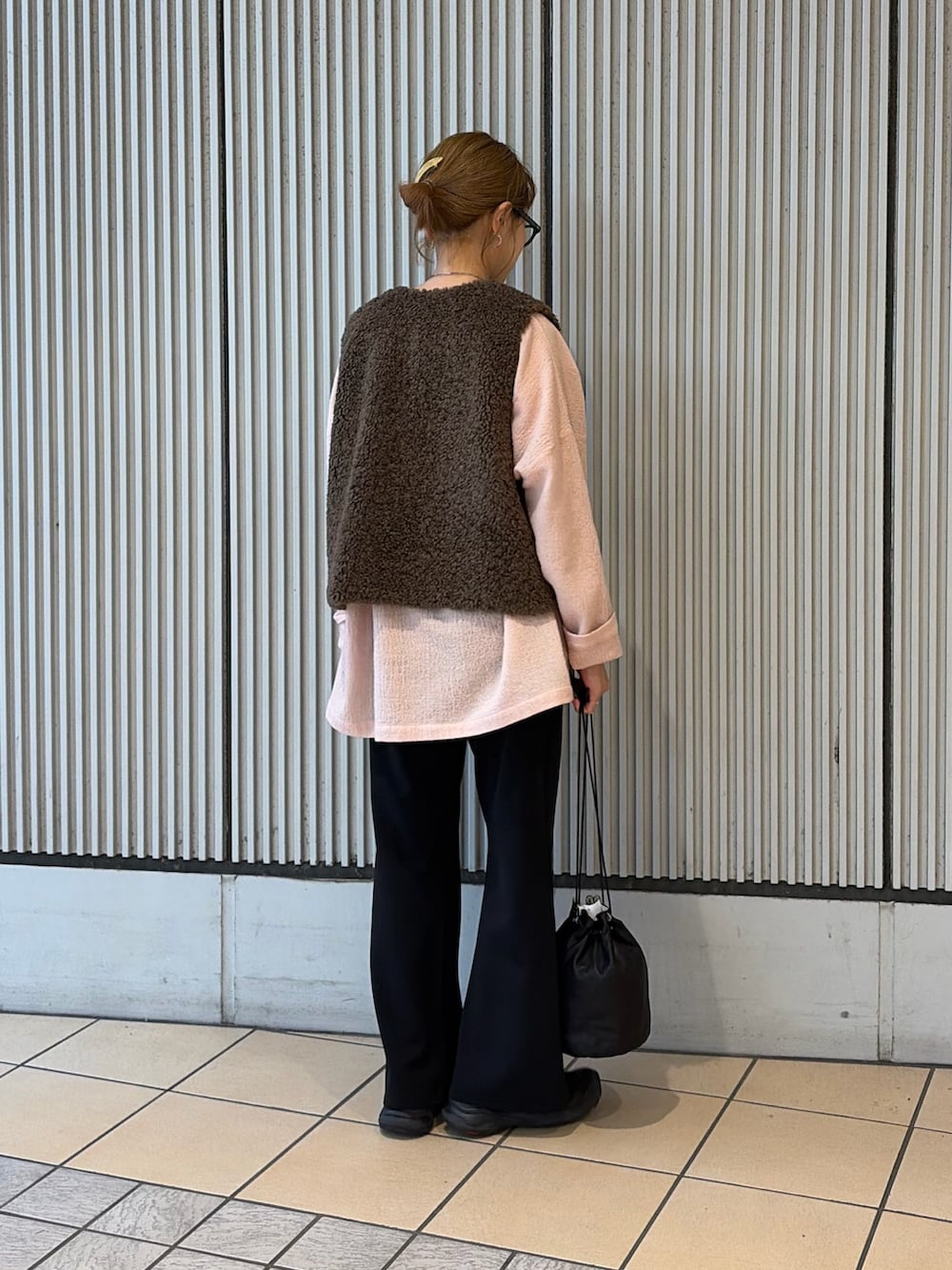 ピンク系のシャツ/ブラウス、ブラウン系のダウンベスト、ブラック系のその他パンツを着用したレディースの秋コーディネートの4枚目の写真
