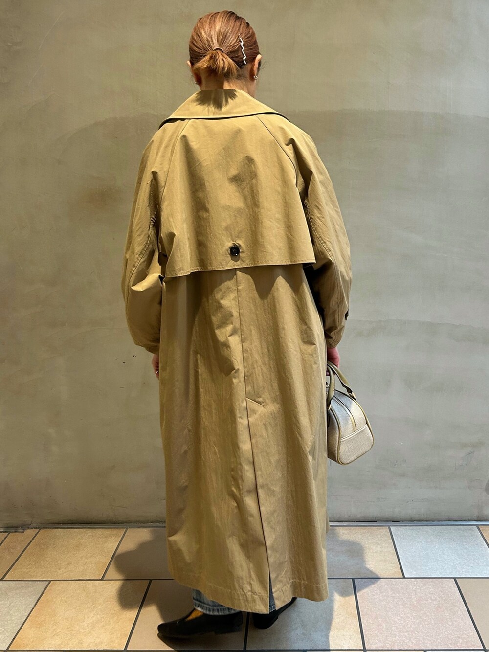 ベージュ系のその他アウター、グレー系のニット/セーター、ホワイト系のTシャツ/カットソーを着用したレディースの冬コーディネートの3枚目の写真