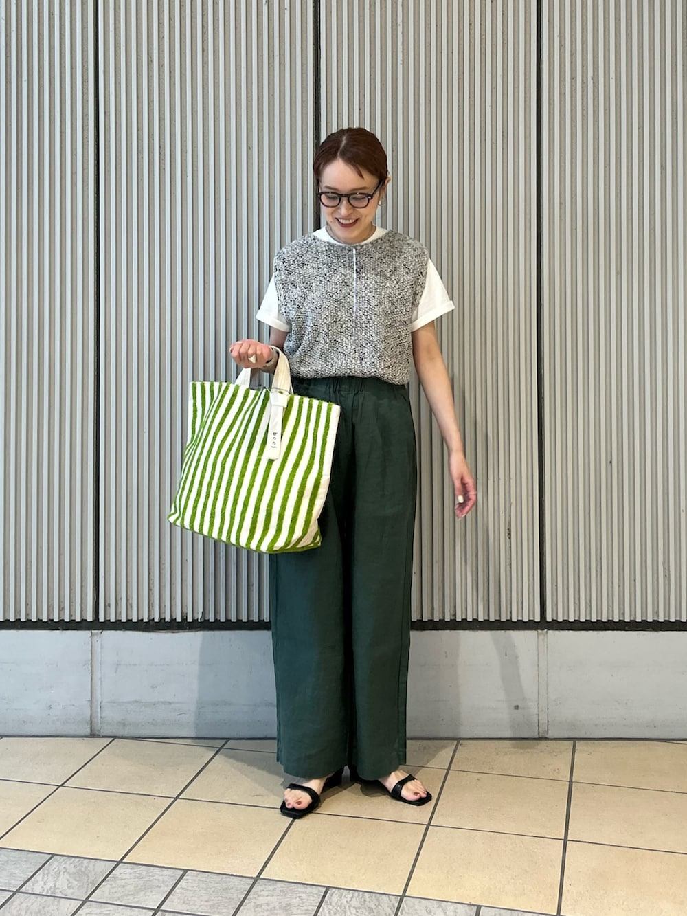 グリーン系のその他パンツ、グレー系のニット/セーター、ホワイト系のTシャツ/カットソーを着用したレディースの春コーディネートの4枚目の写真