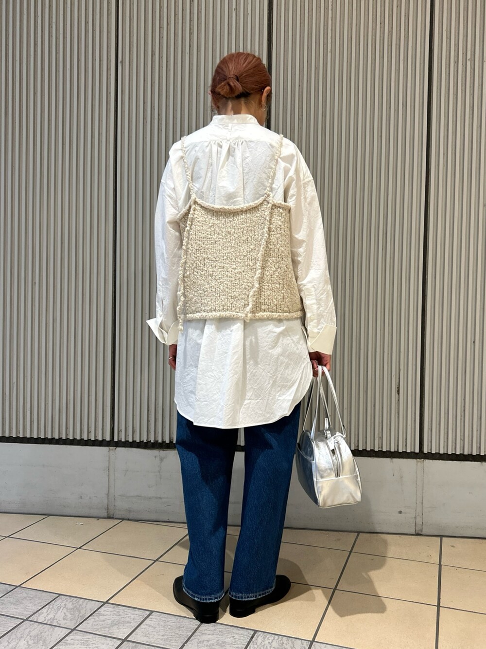 ホワイト系のシャツ/ブラウス、ベージュ系のニット/セーター、ブラック系のブーツを着用したレディースの秋コーディネートの2枚目の写真