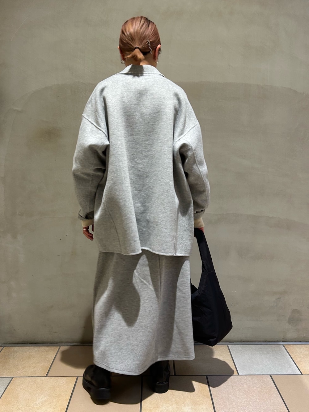 グレー系のその他アウター、ベージュ系のニット/セーター、グレー系のスカートを着用したレディースの冬コーディネートの3枚目の写真