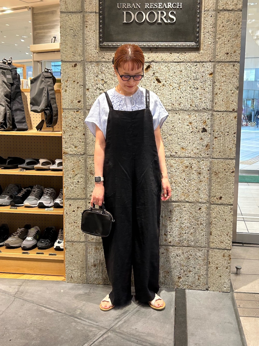 ブラック系のサロペット/オーバーオール、ブルー系のシャツ/ブラウス、ブラック系のショルダーバッグを着用したレディースの春コーディネートの4枚目の写真