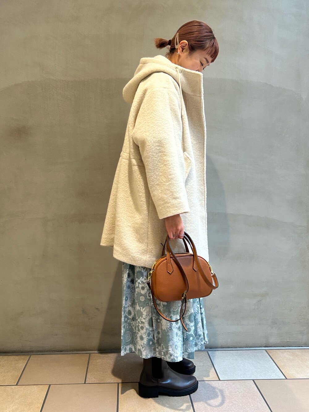 ホワイト系のTシャツ/カットソー、ブルー系のニット/セーター、ブラック系のスカートを着用したレディースの冬コーディネートの3枚目の写真