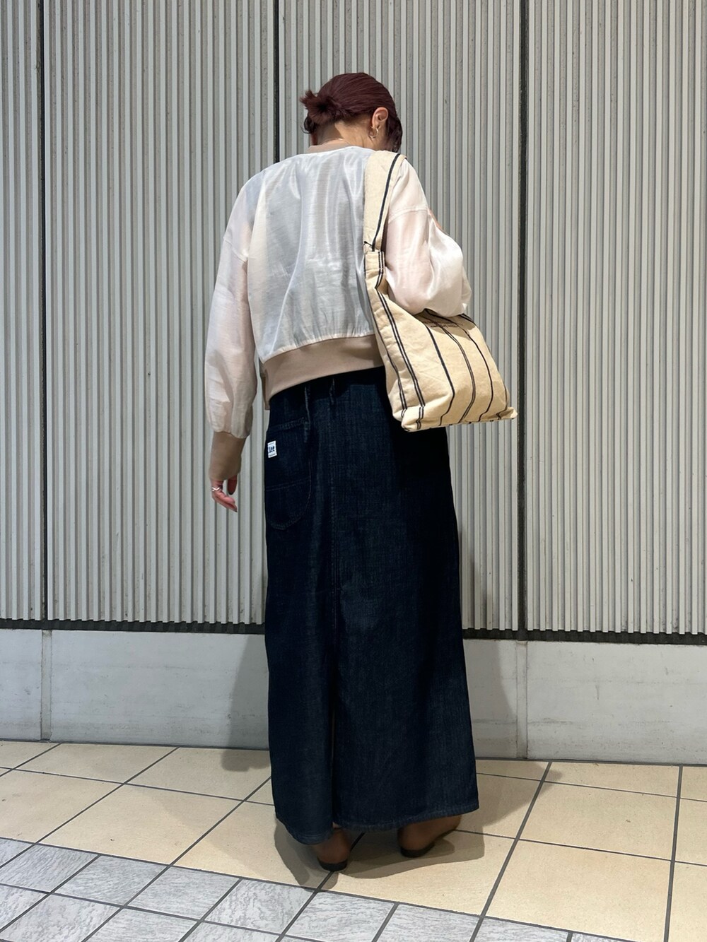 ブルー系のワンピース、ベージュ系のブルゾン、ブラウン系のパンプスを着用したレディースの秋コーディネートの4枚目の写真