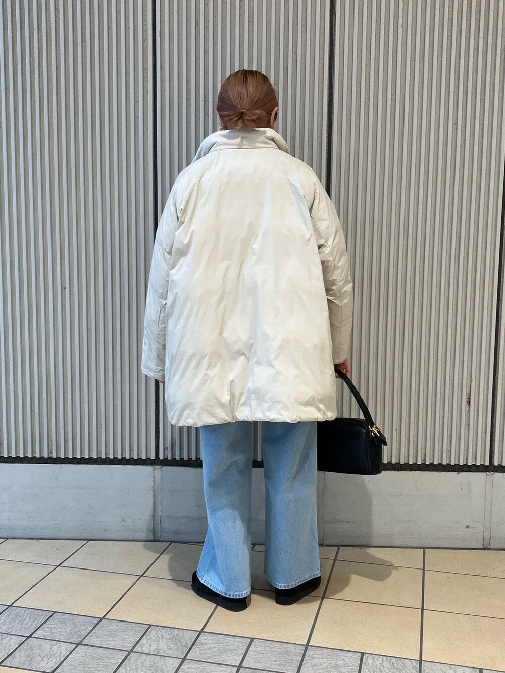 レッド系のカーディガン/ボレロ、ブルー系のデニムパンツ、ブラック系のショルダーバッグを着用したレディースの冬コーディネートの3枚目の写真