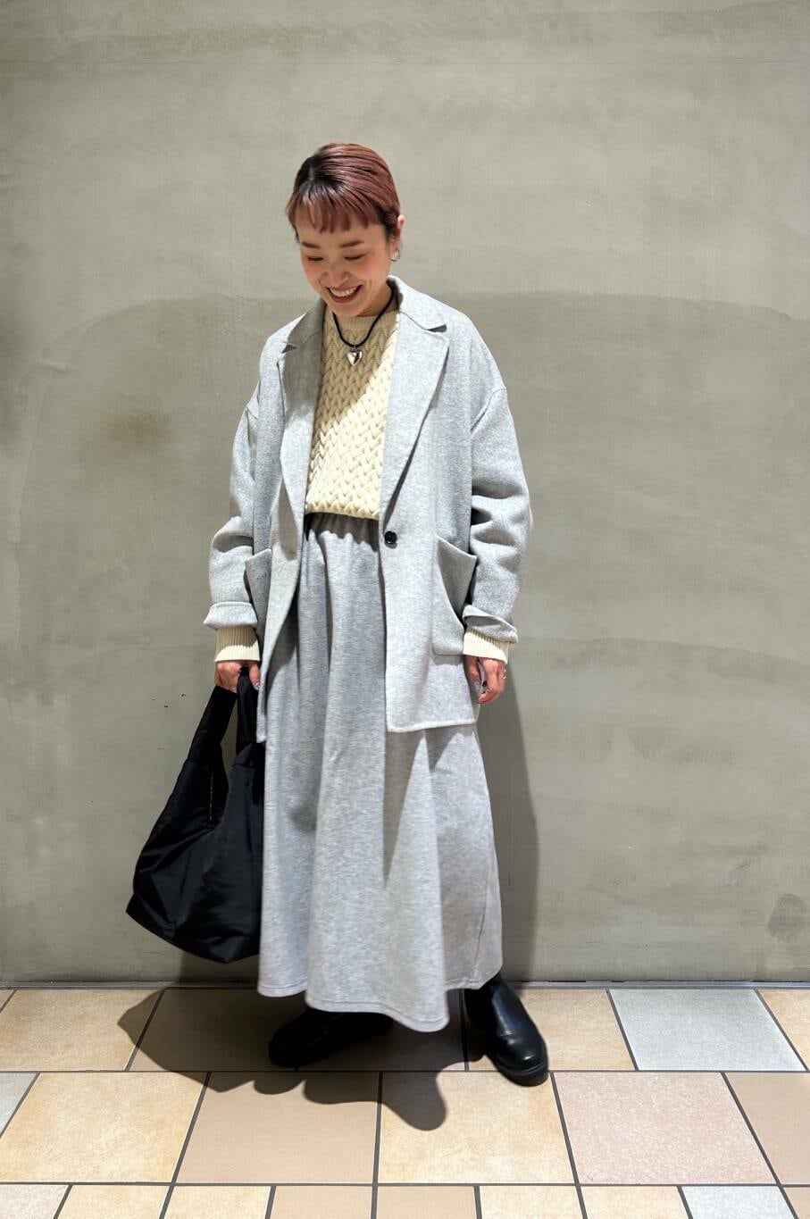 グレー系のその他アウター、ブラック系のブーツ、ブラック系のトートバッグを着用したレディースの冬コーディネートの4枚目の写真