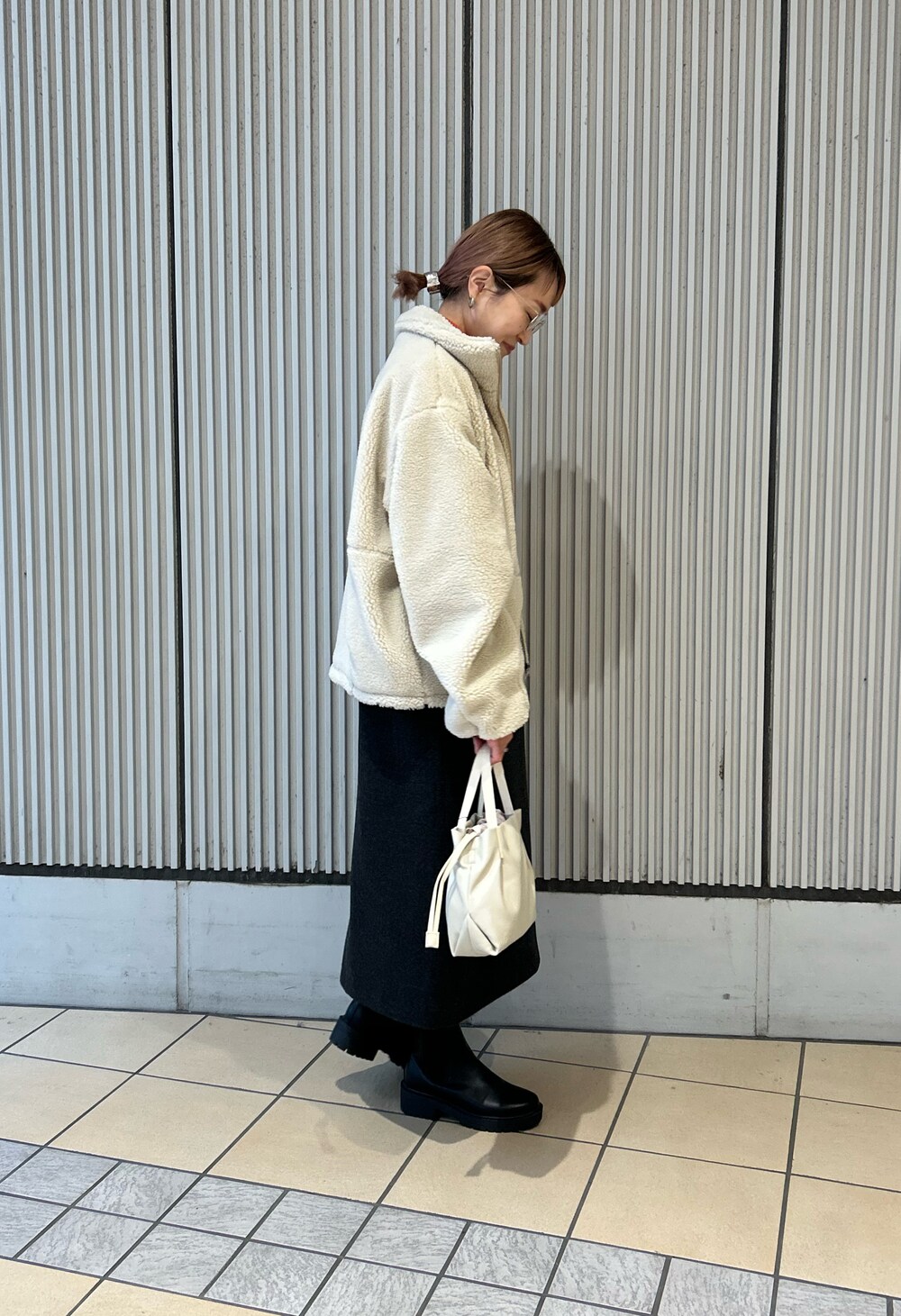 ホワイト系のその他アウター、グレー系のワンピース、ブラック系のブーツを着用したレディースの冬コーディネートの2枚目の写真