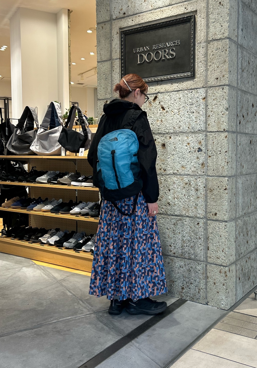 ブラック系のパーカー、ブルー系のスカートを着用したレディースの春コーディネートの3枚目の写真