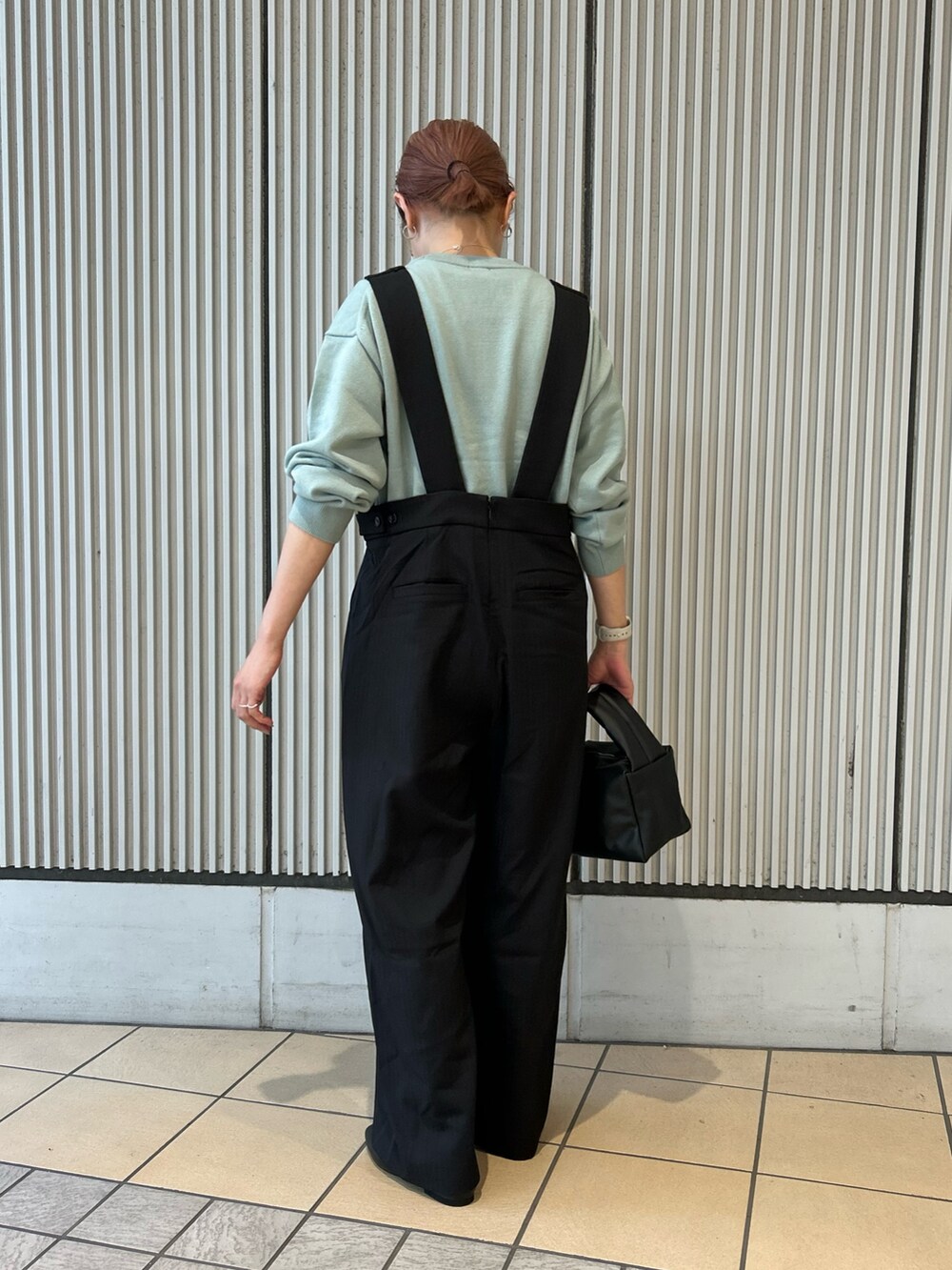ブラック系のワンピース、ブラック系のハンドバッグ、ブラック系のパンプスを着用したレディースの秋コーディネートの2枚目の写真