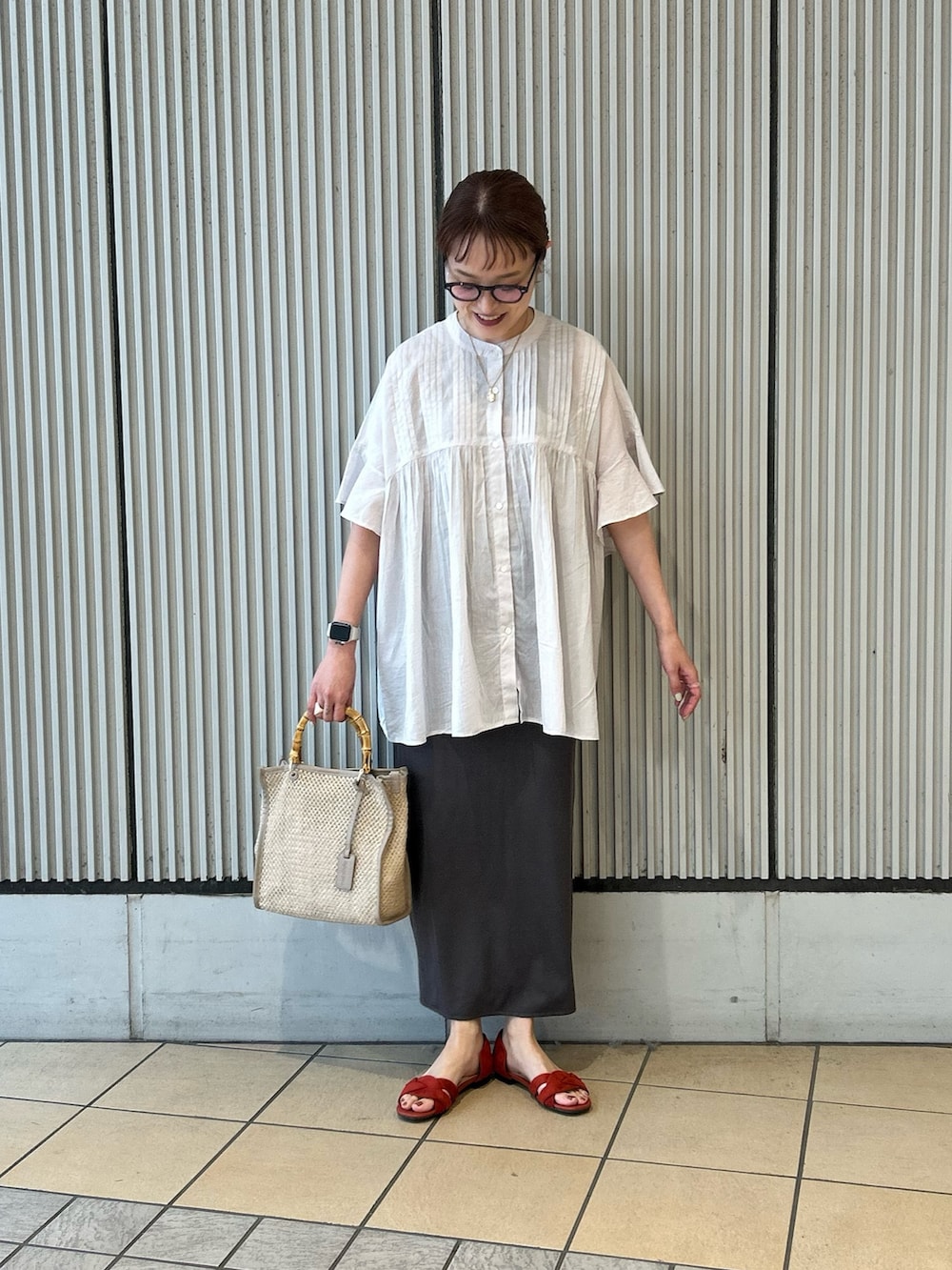 グレー系のシャツ/ブラウス、グレー系のスカート、ベージュ系のショルダーバッグを着用したレディースの春コーディネートの3枚目の写真