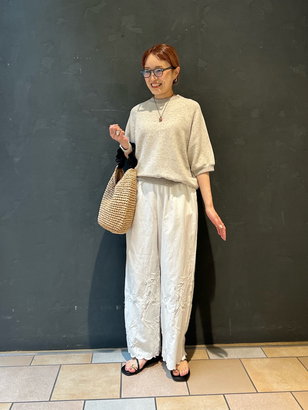 グレー系のスウェット、ホワイト系のその他パンツ、ブラック系のサンダルを着用したレディースの春コーディネートの3枚目の写真