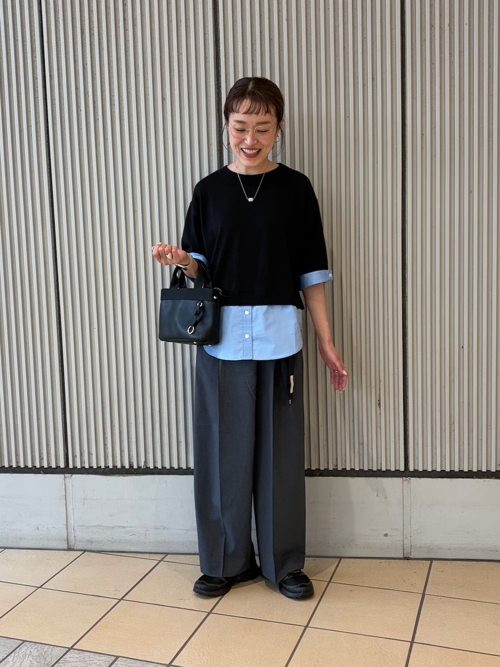 ブラック系のニット/セーター、グレー系のその他パンツ、ブラック系のスニーカーを着用したレディースの夏コーディネートの3枚目の写真