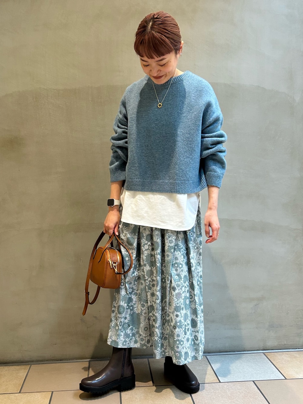 ホワイト系のTシャツ/カットソー、ブルー系のニット/セーター、ブラック系のスカートを着用したレディースの冬コーディネートの5枚目の写真