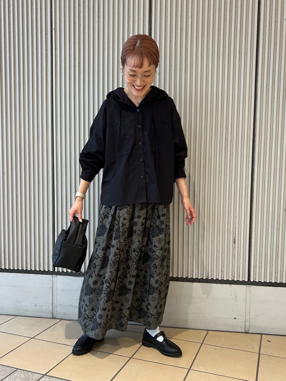 ブラック系のシャツ/ブラウス、グレー系のスカート、ブラック系のハンドバッグを着用したレディースの秋コーディネートの4枚目の写真