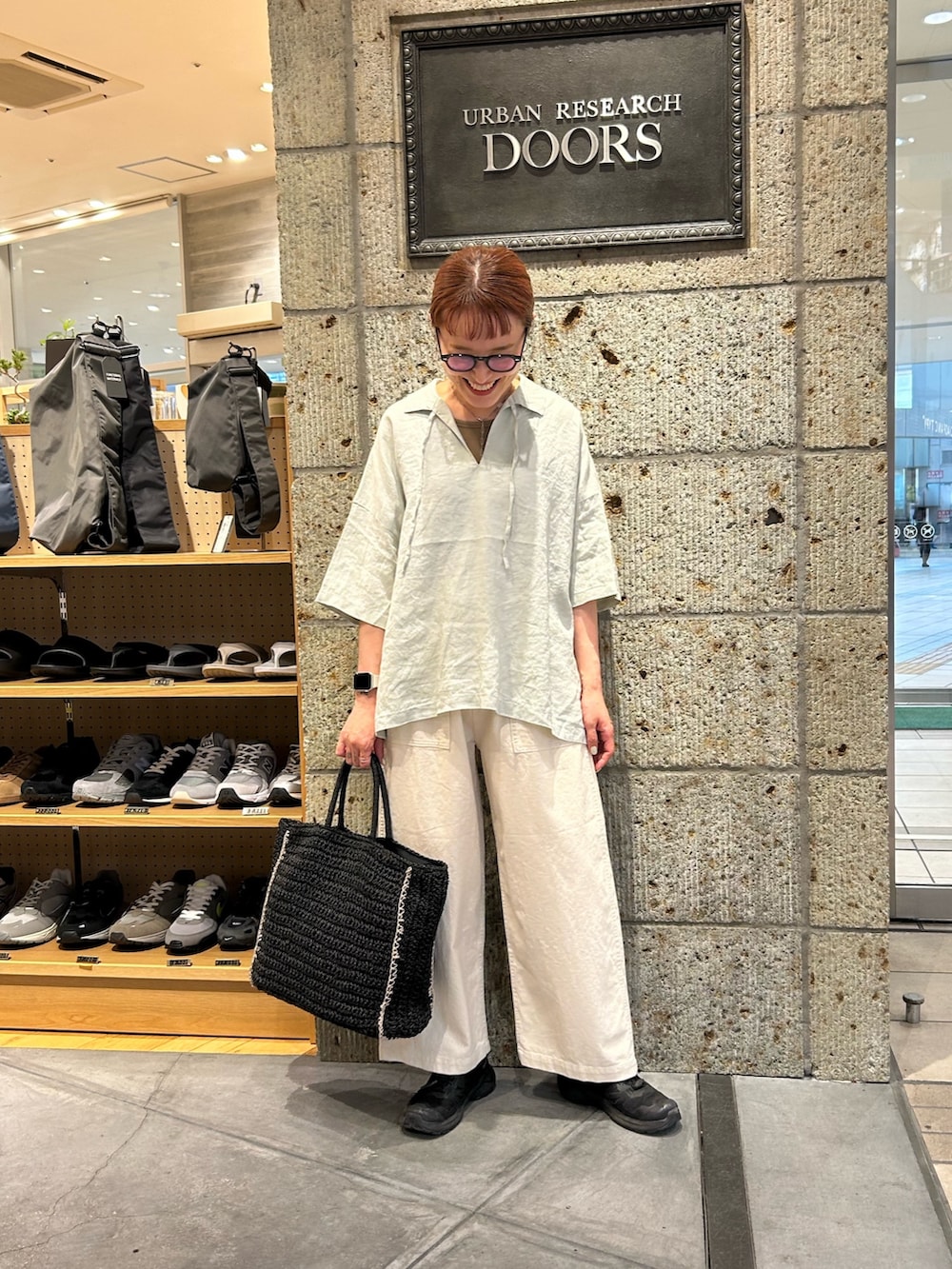 グリーン系のシャツ/ブラウス、ホワイト系のその他パンツ、ブラック系のトートバッグを着用したレディースの春コーディネートの4枚目の写真