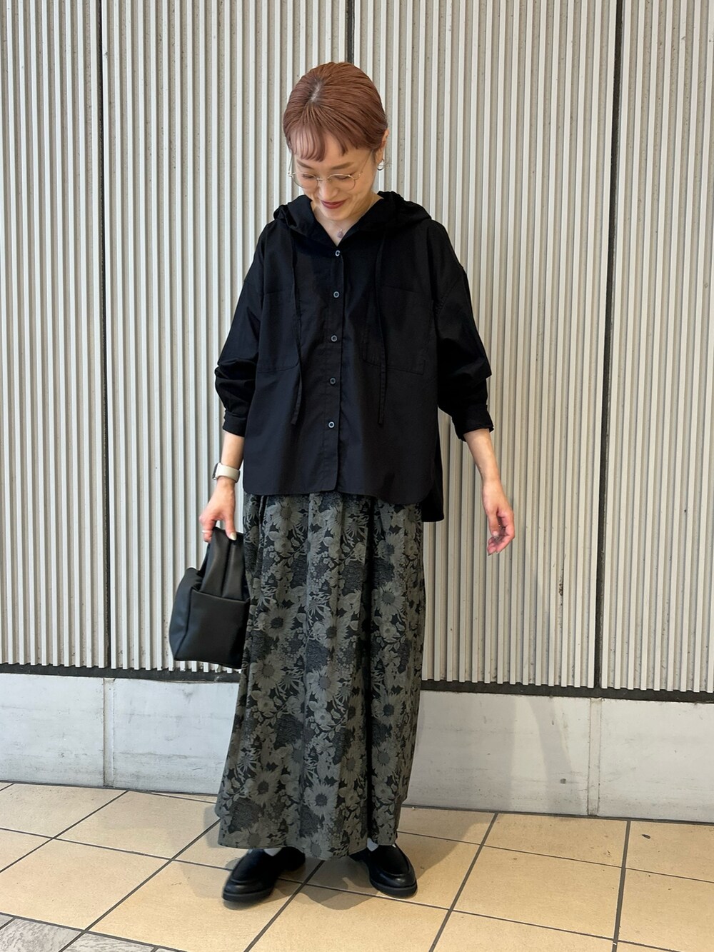 ブラック系のシャツ/ブラウス、グレー系のスカート、ブラック系のハンドバッグを着用したレディースの秋コーディネートの2枚目の写真
