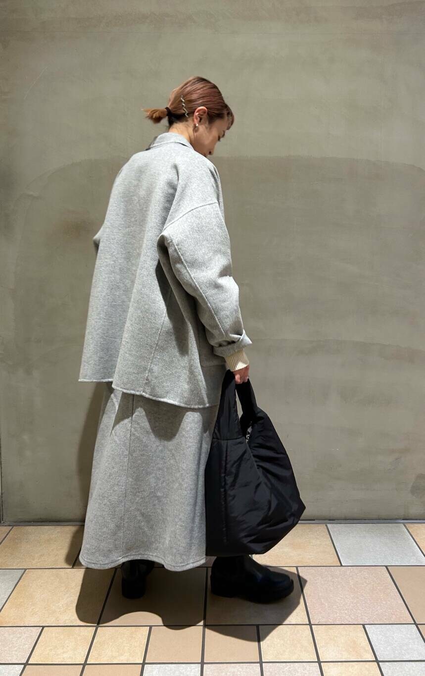 グレー系のその他アウター、ブラック系のブーツ、ブラック系のトートバッグを着用したレディースの冬コーディネートの2枚目の写真