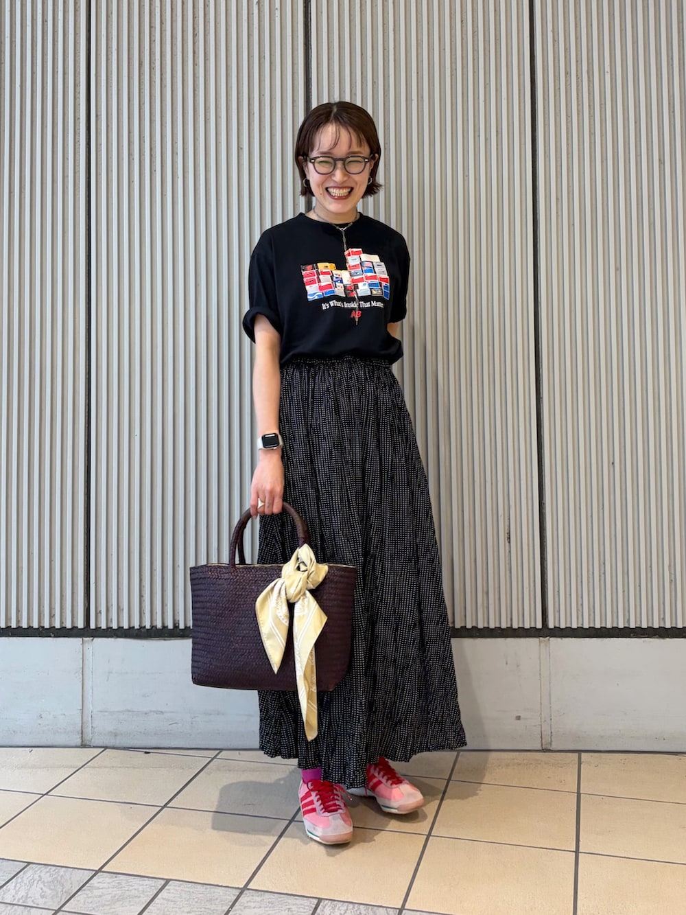 ブラック系のTシャツ/カットソー、ブラック系のスカート、レッド系のトートバッグを着用したレディースの夏コーディネートの4枚目の写真
