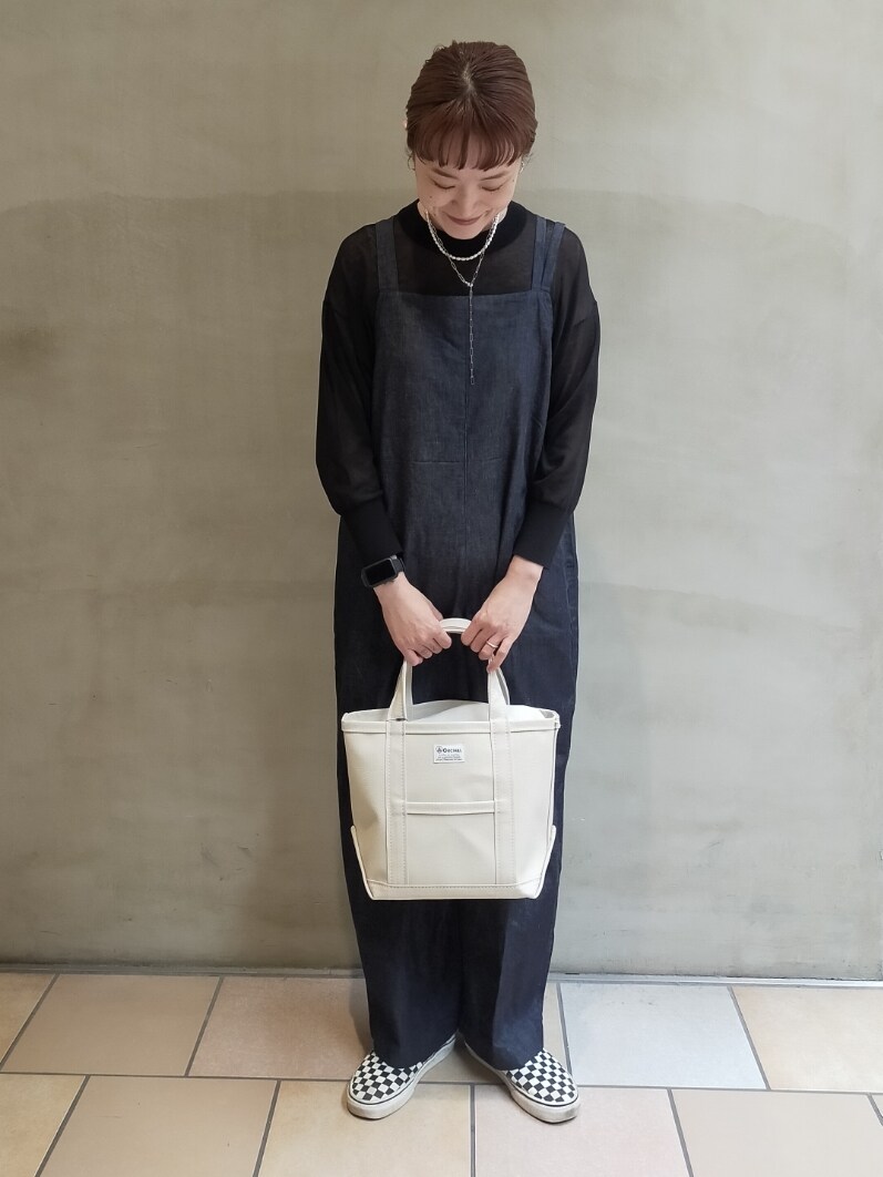 ブルー系のオールインワン・サロペット、ホワイト系のトートバッグ、ブラック系のニット/セーターを着用したレディースの夏コーディネートの3枚目の写真