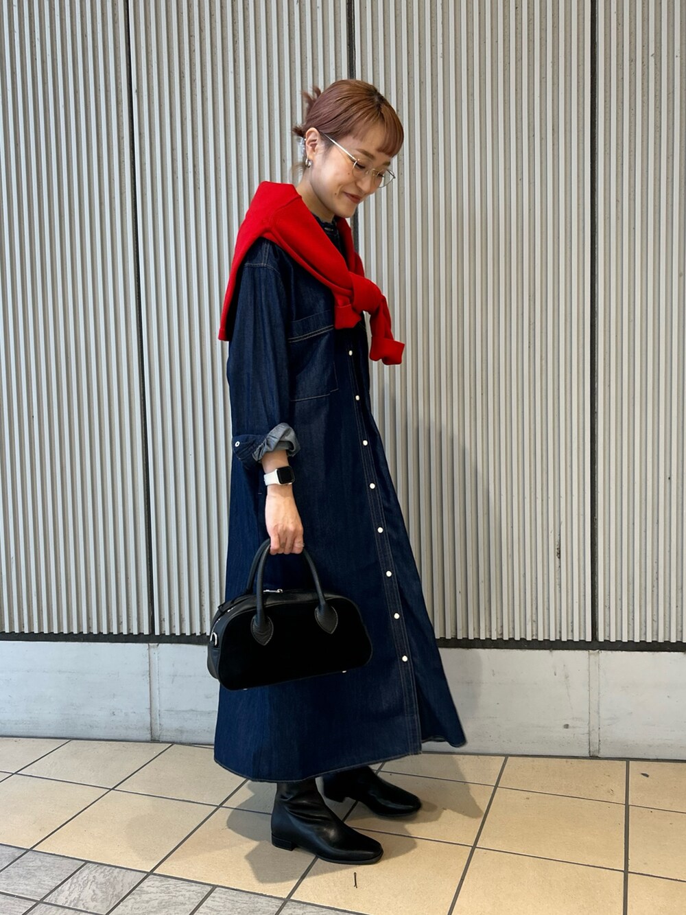 ブルー系のワンピース、レッド系のカーディガン/ボレロ、ブラック系のショルダーバッグを着用したレディースの秋コーディネートの2枚目の写真