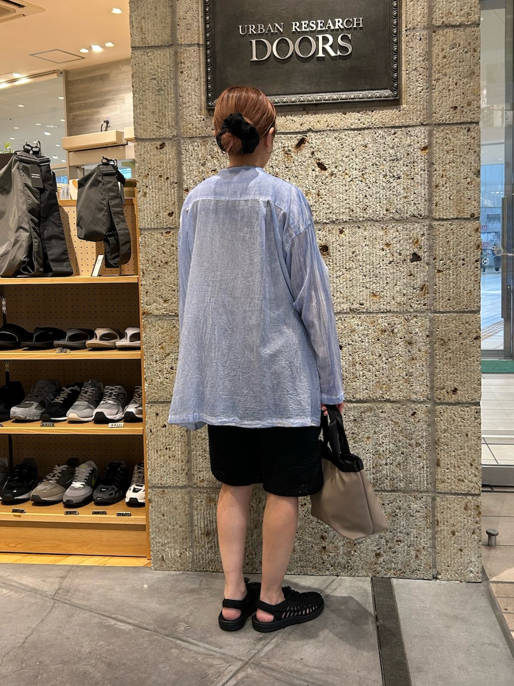 ブルー系のシャツ/ブラウス、ブラック系のその他パンツ、グレー系のハンドバッグを着用したレディースの春コーディネートの2枚目の写真