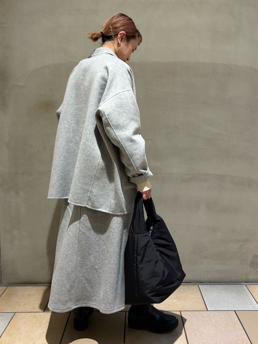 グレー系のその他アウター、ベージュ系のニット/セーター、グレー系のスカートを着用したレディースの冬コーディネートの2枚目の写真