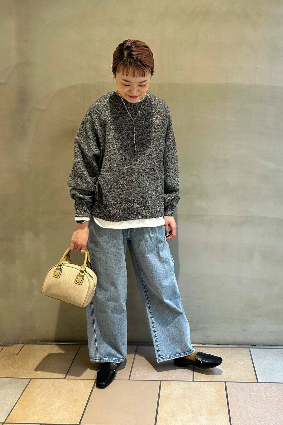 ブラック系のローファー、ホワイト系のTシャツ/カットソー、ブルー系のデニムパンツを着用したレディースの冬コーディネートの5枚目の写真