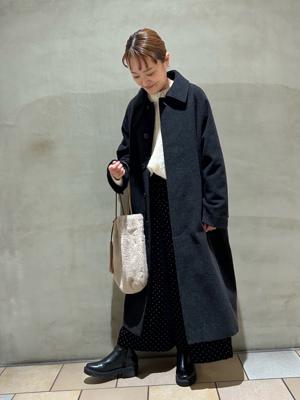 グレー系のその他アウター、ホワイト系のニット/セーター、ブラック系のパンツを着用したレディースの秋コーディネートの2枚目の写真