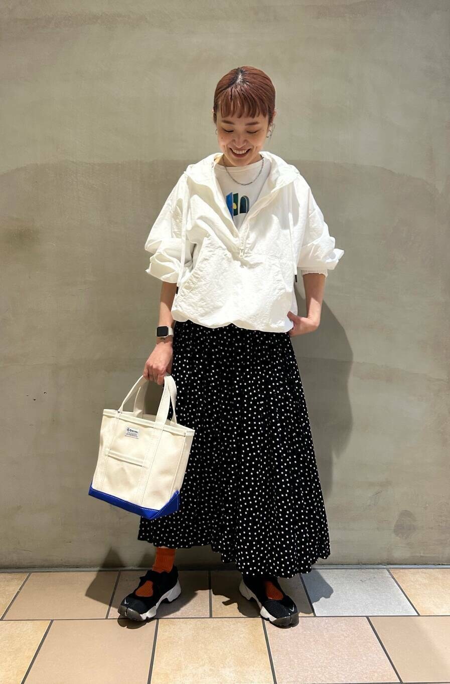 ホワイト系のパーカー、ブラック系のスカート、ホワイト系のTシャツ/カットソーを着用したレディースの春コーディネートの2枚目の写真