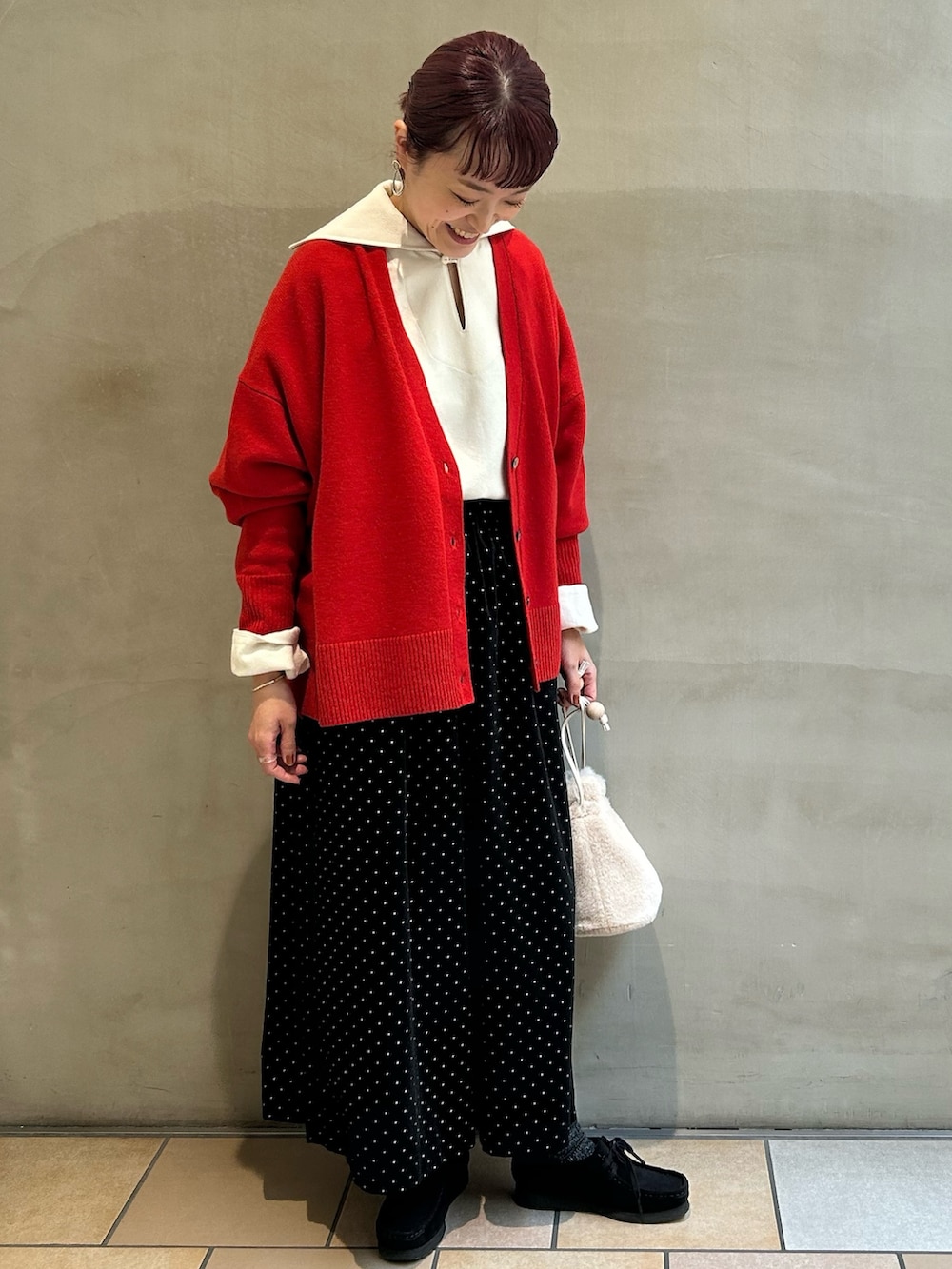 レッド系のニット/セーター、ブラック系のその他パンツ、ホワイト系のその他トップスを着用したレディースの冬コーディネートの4枚目の写真