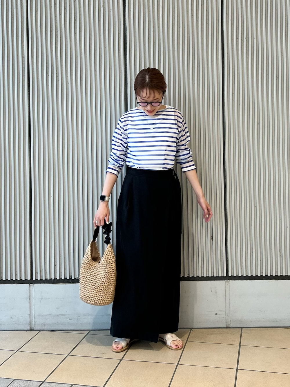ブルー系のTシャツ/カットソー、ブラック系のスカート、ホワイト系のサンダルを着用したレディースの夏コーディネートの4枚目の写真