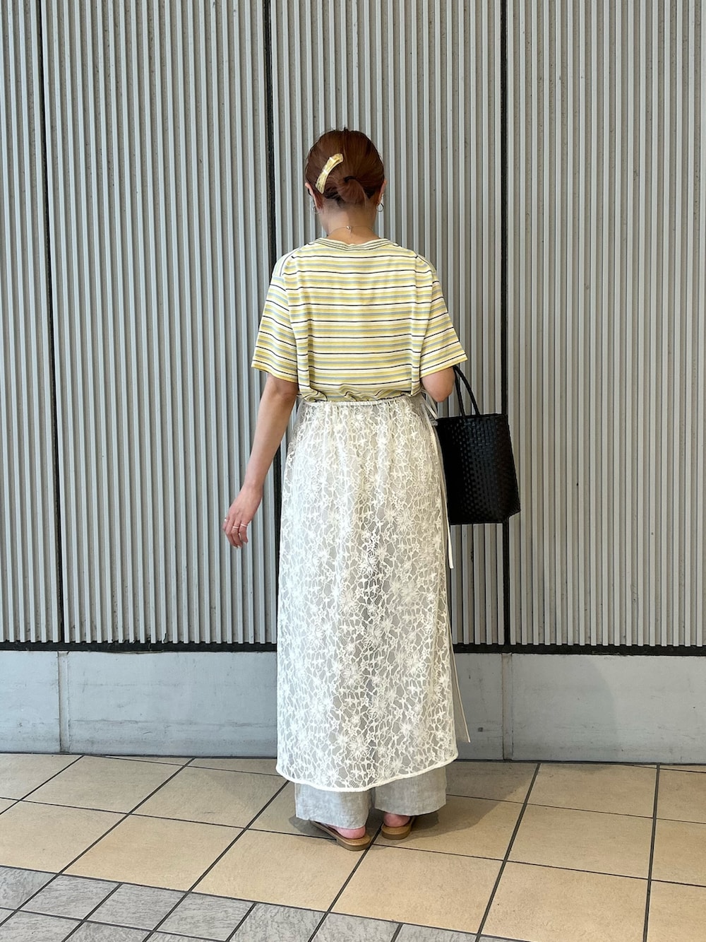 ブラウン系のかごバッグ、ベージュ系のその他パンツ、ホワイト系のサンダルを着用したレディースの夏コーディネートの3枚目の写真