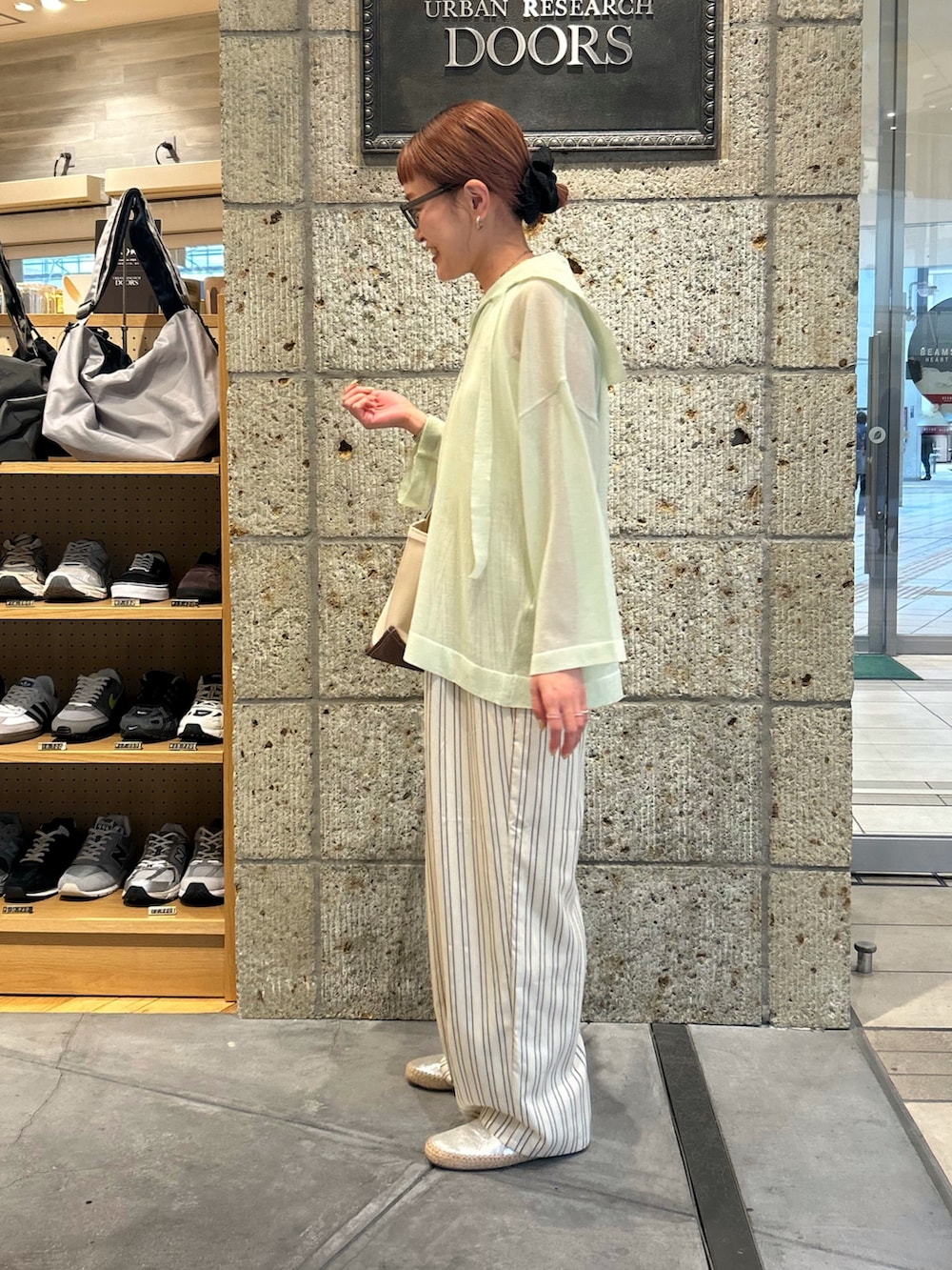 ベージュ系のその他パンツ、シルバー系のスリッポン、グリーン系のトートバッグを着用したレディースの春コーディネートの2枚目の写真