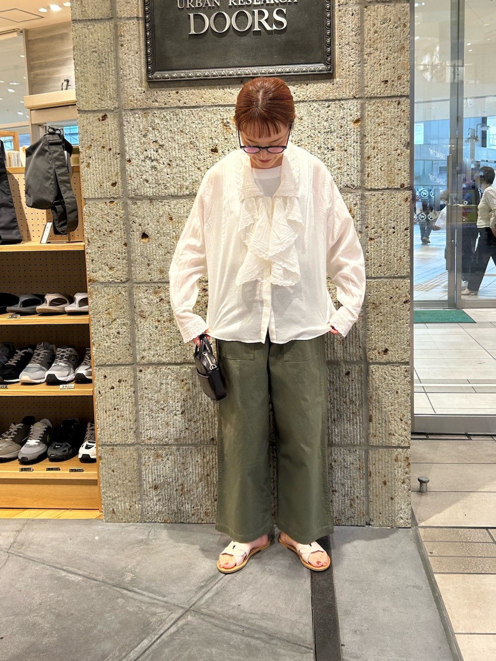 グリーン系のその他パンツ、ホワイト系のサンダル、ブラック系のショルダーバッグを着用したレディースの春コーディネートの3枚目の写真