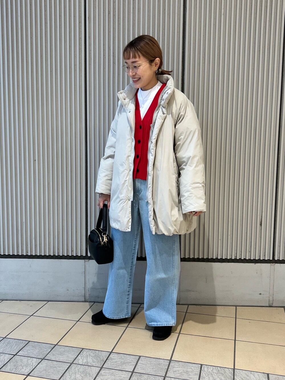 レッド系のカーディガン/ボレロ、ブルー系のデニムパンツ、ブラック系のショルダーバッグを着用したレディースの冬コーディネートの4枚目の写真