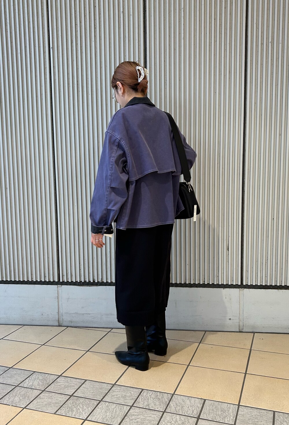 ブルー系のテーラードジャケット、ブラック系のワンピース、ブラック系のブーツを着用したレディースの冬コーディネートの2枚目の写真