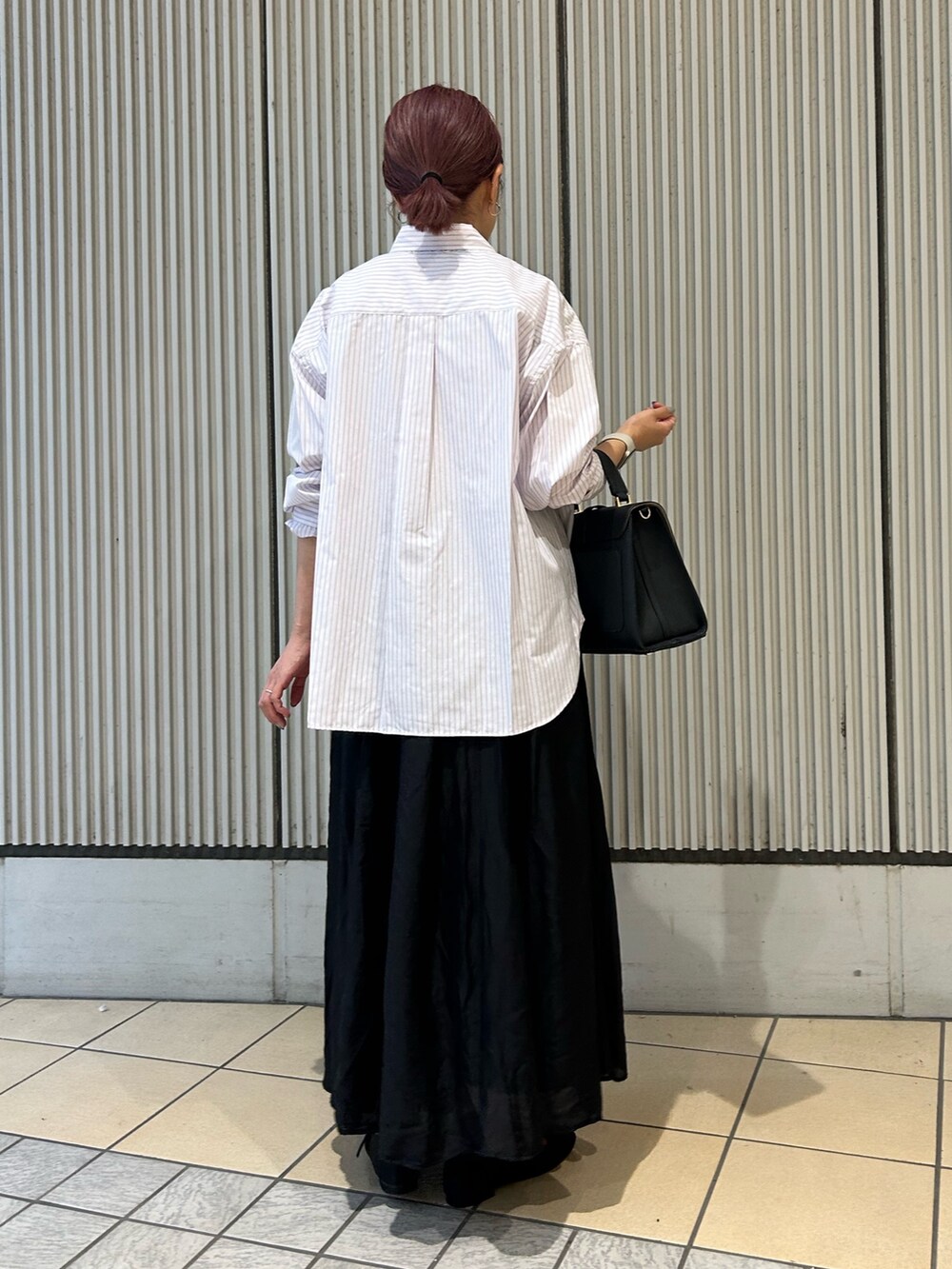 ブラック系のスカート、ブラック系のパンプス、ピンク系のシャツ/ブラウスを着用したレディースの秋コーディネートの2枚目の写真