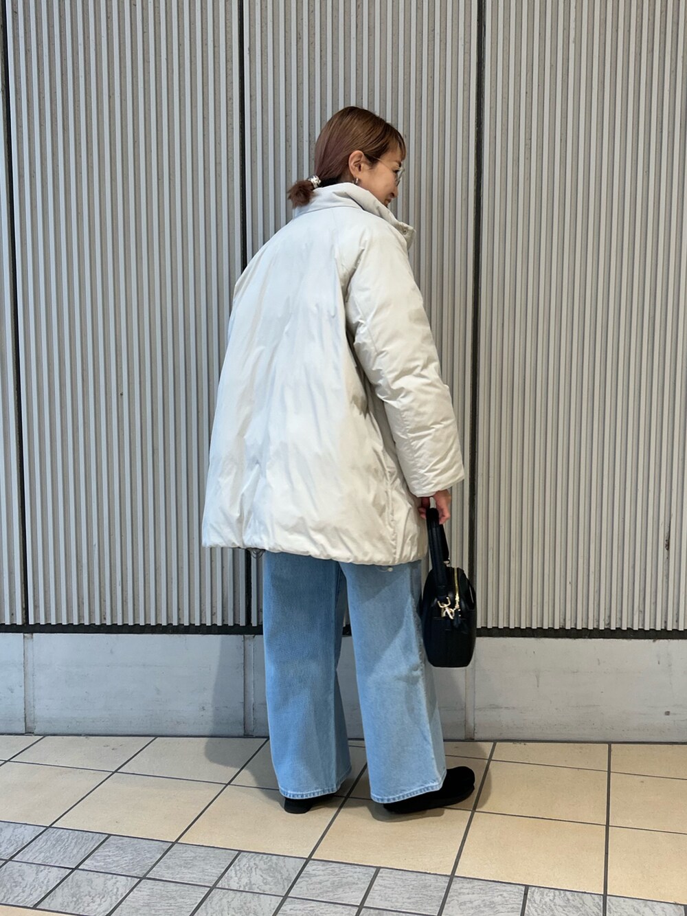 レッド系のカーディガン/ボレロ、ブルー系のデニムパンツ、ブラック系のショルダーバッグを着用したレディースの冬コーディネートの2枚目の写真