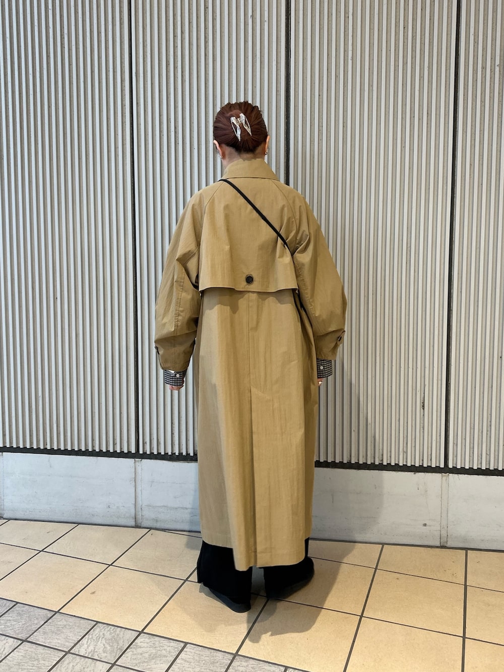 ベージュ系のトレンチコート、ブラック系のシャツ/ブラウス、ブラック系のその他パンツを着用したレディースの冬コーディネートの2枚目の写真