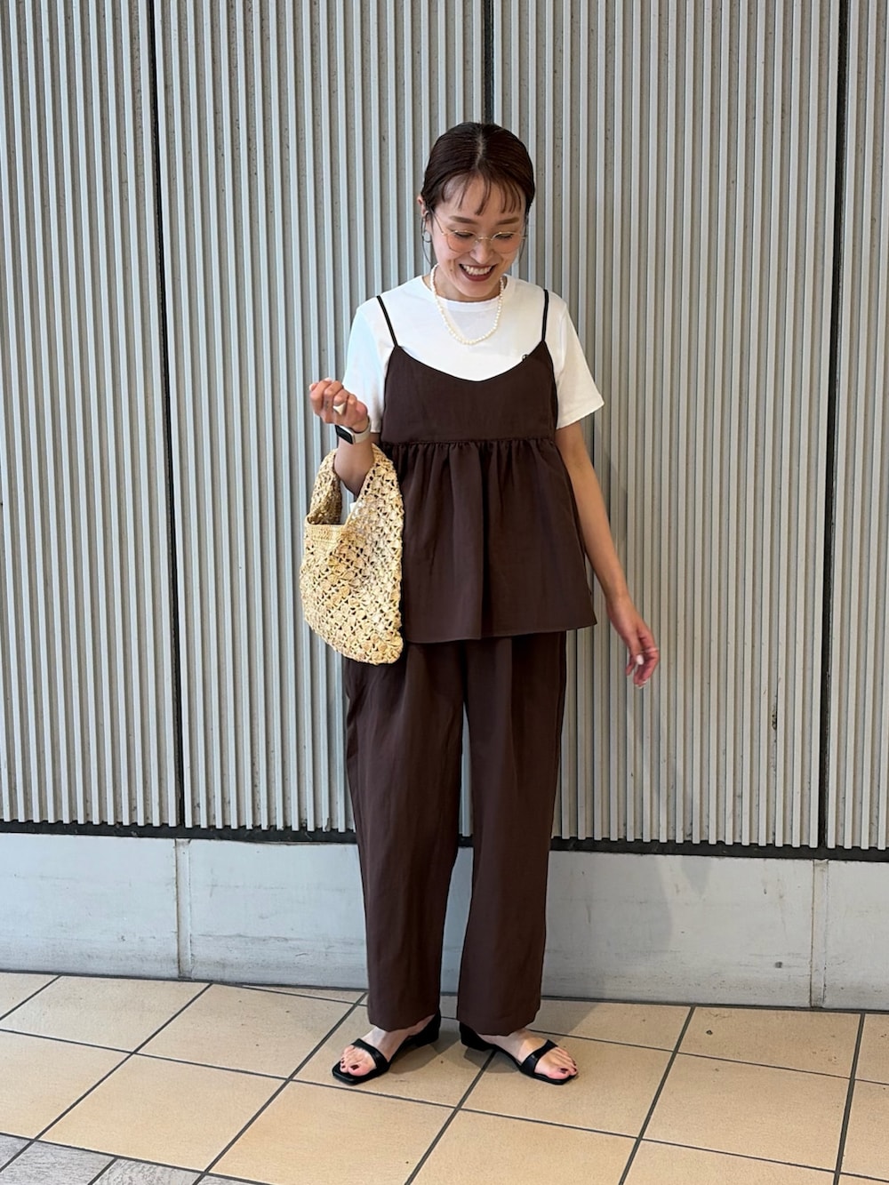 ホワイト系のTシャツ/カットソー、ブラック系のサンダル、ベージュ系のハンドバッグを着用したレディースの夏コーディネートの3枚目の写真